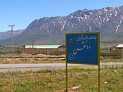 Blue welcome sign against a rural mountain background high desert and in Iran