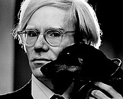A black and white photo of Andy Warhol with a dog