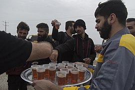 An Iranian volunteer distributing free drinks