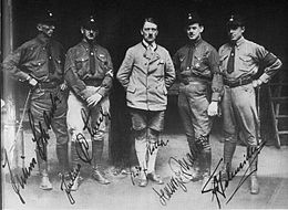 Black-and-white photo of five men in uniforms, with Hitler stood in the center