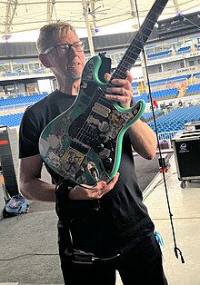 Karl Koch holding a guitar belonging to Weezer lead singer Rivers Cuomo