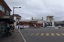 Passerelle en construction au-dessus d'une route et de quais de bus.