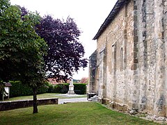 Façade de l'église, et au fond le monument aux morts.