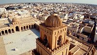 Photographie aérienne de la Grande Mosquée de Kairouan, montrant de près le dernier niveau du minaret qui correspond au lanternon. Celui-ci est surmonté d'une coupole.