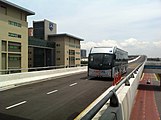 A BRT Sunway Line bus approaching SunU-Monash BRT station. The Monash University campus can be seen.