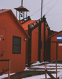 small cluster of orange buildings with the center one having a short bell tower on top.