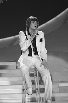 Black and white photograph of Johnny Logan performing on stage at the 1980 contest