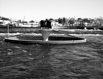 La fontaine recyclée après l'action performative de Jocelyn Maltais. Les fosses septiques installées sur la fontaine ont été enlevées en 1987 à la suite de la dépollution de la rivière Petite Décharge à Alma.