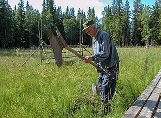 Markägaren Allan Sällström visar hur man underhåller bevattningskanalerna med förhuggare (juli 2003).