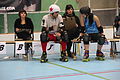 Un joueur et une joueuse de roller derby discutant sur le banc des pénalités