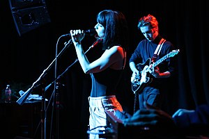 María performing alongside Jesse Perlman on a darkened stage.