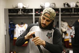 Photographie couleur d'un homme avec une crosse de hockey