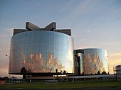 Photographie d'un bâtiment moderne aux façades de verre dans une ville nouvelle.