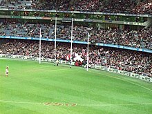 Four tall white posts spaced in a line, the outer pair somewhat shorter.