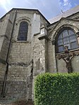 Arrière de l'église avec un vitrail et le calvaire.