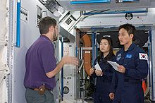 Yi So-yeon and Ko San participate in a space station hardware training session in the Space Vehicle Mockup Facility at the Johnson Space Center by Crew Systems instructor Glenn Johnson.