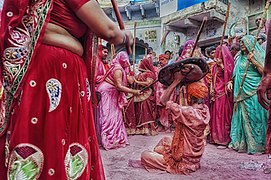 Femmes frappants un homme dans le cadre des festivités du Lathmar Holi à Barsana. Une célébration typique de la région de Mathura.