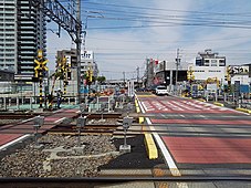 知立駅東側の“開かずの踏切”（牛田6号：名古屋本線（奥）／知立1号：三河線（手前））。2路線の踏切が連続している上に、三河線は碧南・猿投両方面の列車がすべて通過するため、遮断時間が長く交通渋滞の原因となっていた。