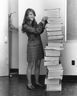 L'informaticienne et mathématicienne américaine Margaret Hamilton se tenant auprès du code du logiciel de navigation qu'elle et son équipe ont produit pour le programme Apollo. (définition réelle 2 294 × 2 856)