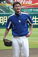 Hitoki Iwase wearing a blue and white baseball uniform standing with his glove