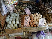 Duck eggs (left), larger and greener than chicken eggs (right) at market, Hong Kong, 2022