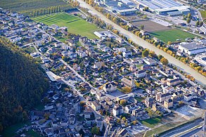 Village vu de haut à côté d'un fleuve. Les rues et les maisons sont facilement distinguables.