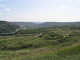 A green valley with a river and a road running somewhat parallel to the river