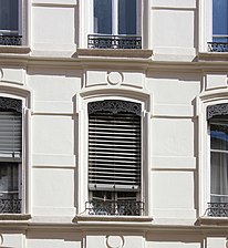 Une fenêtre lyonnaise avec un store appelé jalousie se déroulant à partir d'un lambrequin.