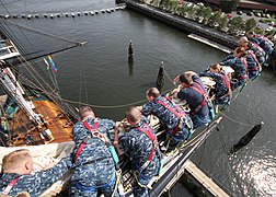 Les gabiers se déplacent sur un marchepied (sous la vergue pour se déplacer le long de la vergue (ici les cadets de l'US Navy sur l'USS Constitution).