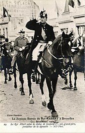 Photographie en noir et blanc d'un homme en uniforme à cheval saluant militairement