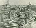 A group of men stand near the Manassas Railroad Junction railroad tracks in 1862 with a train in the background