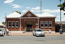The exterior of the Coonabarabran post office from the street. It is red brick with white detailing.