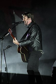 A young man singing in a concert.