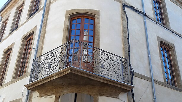 Balcon d'angle orné d'une ferronnerie.