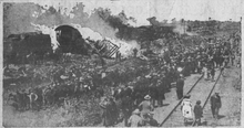 Black and white photo show a wreck surrounded by onlookers