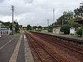 A view of the platforms and tracks. The siding can be seen in the distance, branching off to the left.