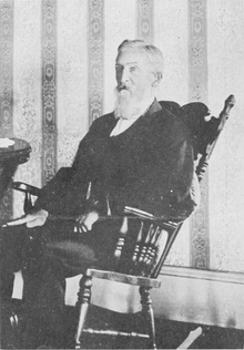 Man with beard in victorian suit in rocking chair