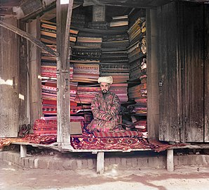 Mercante mostra colorate stoffe di seta, cotone e lana