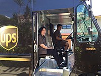 The UPS Driver Helper sits in a jump seat