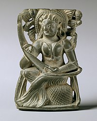 Sculpture of woman playing a bow harp