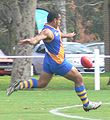 Nauruan player kicks the ball downfield
