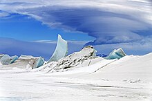 Un important nuage est visible au-dessus du sol neigeux.