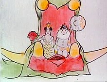 A color film still. A green dragon with its mouth gaping wide carries a fancily-dressed boy and girl. The girl, to the left, carries a large rose, and the boy, to the right, waves with his hat towards the audience.