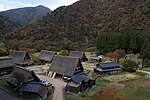 Wooden thatched houses in a mountainous landscape.