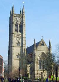 A stone church seen from the west, with a tall pinnacled tower