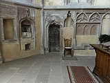 Armoire eucharistique et porte de la sacristie entourée de reliefs.