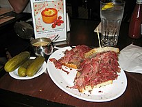 A pastrami on rye with kosher dill pickles and spicy brown mustard