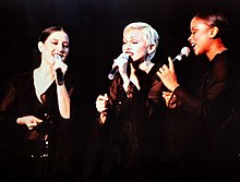 From left Donna de Lory, Madonna and Niki Haris singing onstage wearing black garments.