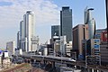 名駅高層ビル群を背景に名古屋駅から発車した新幹線