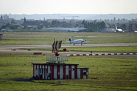 L'ancien radar TA10 de l'aéroport d'Orly, désormais à l'arrêt. Un avion de la Pan Européenne Air Service est en train d'atterrir. Au fond, on peut voir le Concorde et le Mercure du musée Delta.